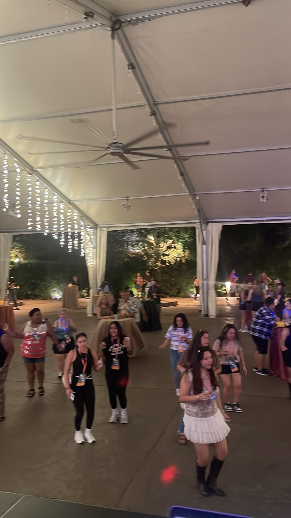 Guests dancing under a lit tent at night