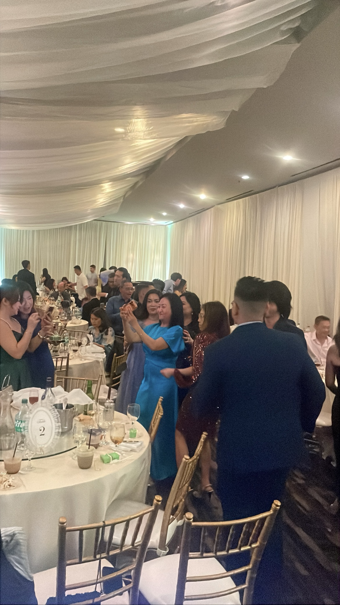 Reception guests mingling around candlelit tables