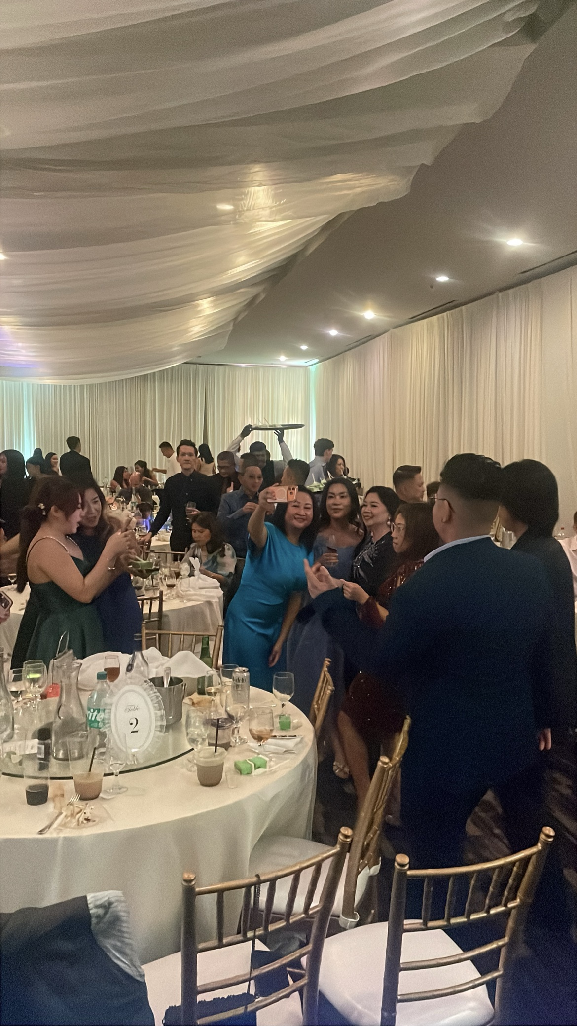 Packed wedding reception with guests dancing