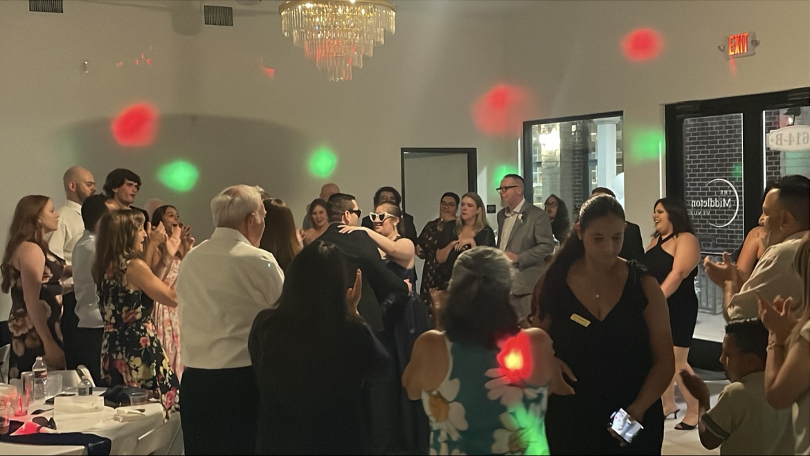 Guests dancing at a venue lit with red and green party lights
