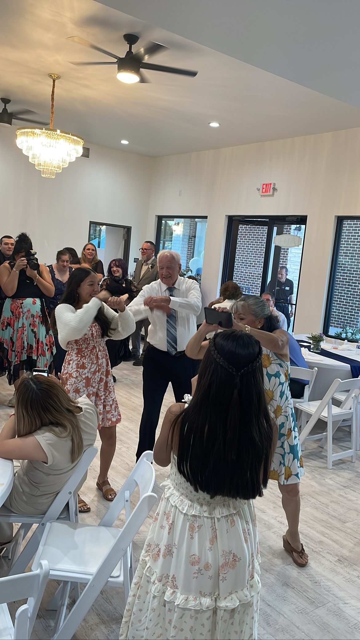Couple dancing on a bright ballroom floor with guests watching