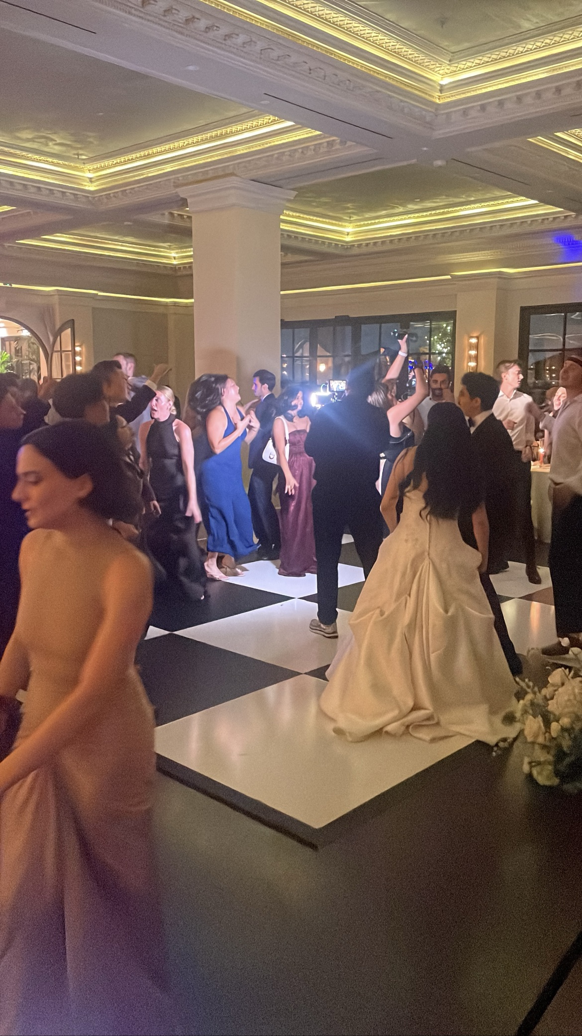 Bride in a white gown dancing on a checkered floor