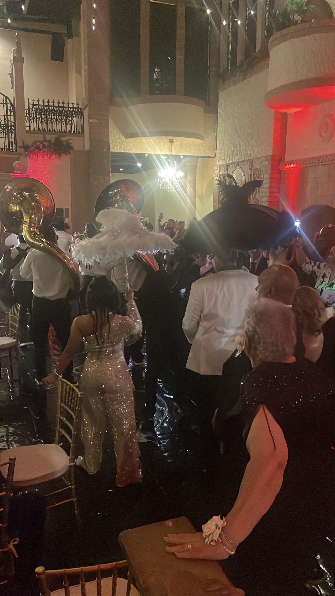 Second line parade with the bride and a feather umbrella indoors